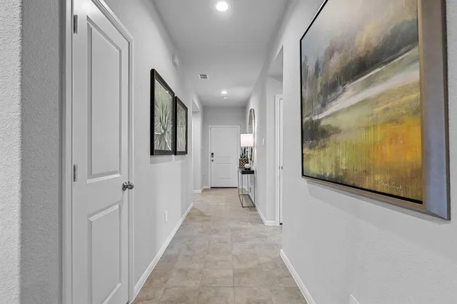 a view of a hallway with wooden floor and windows