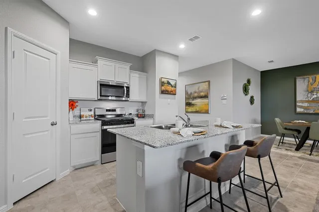 a kitchen with stainless steel appliances a refrigerator and a stove top oven