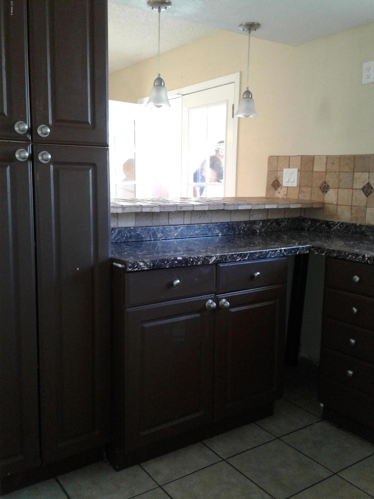8416 West Roma Avenue Phoenix, AZ 85037 - Photo 11 of 33 a kitchen with a granite countertop sink stove and cabinets