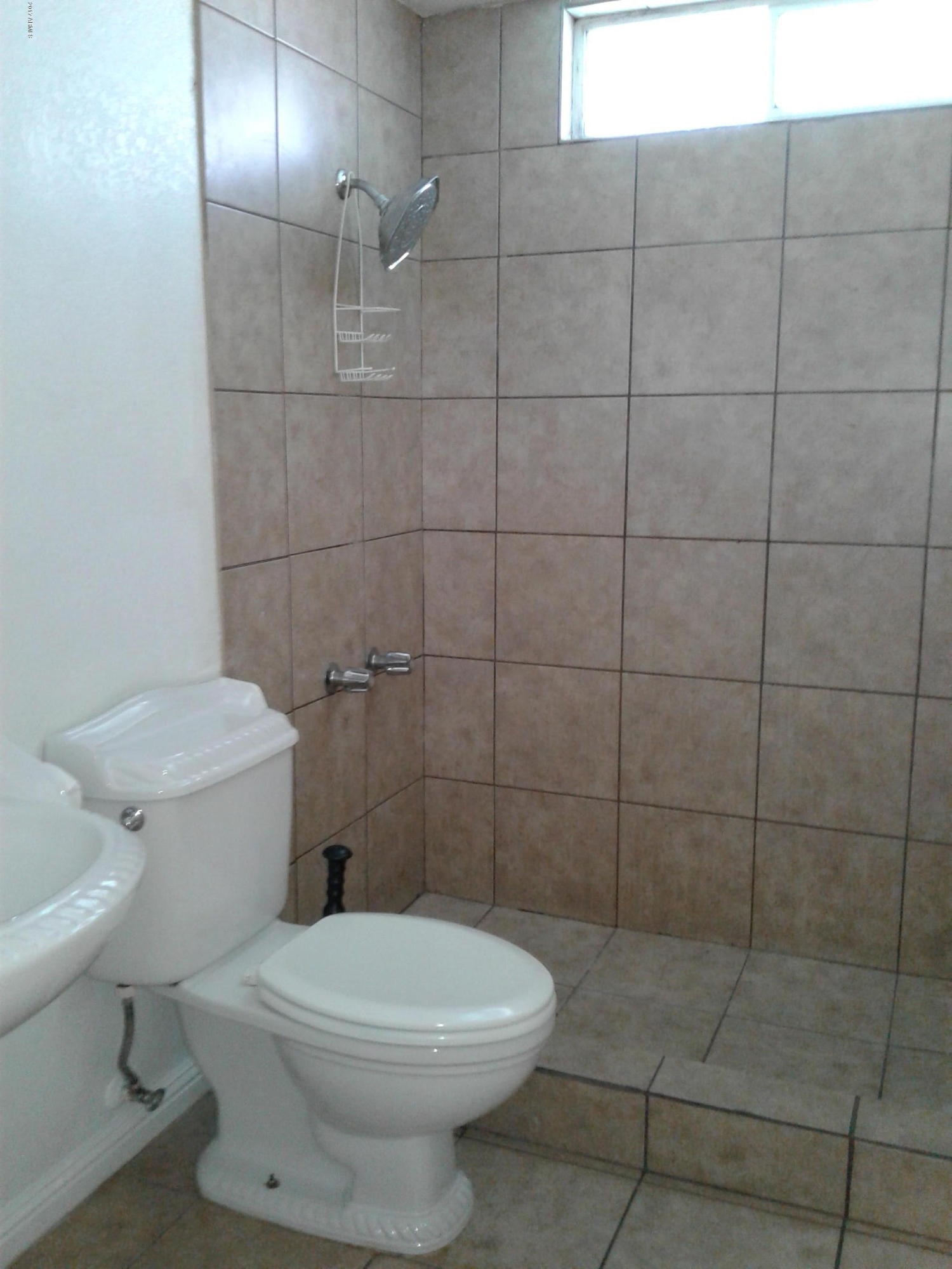 8416 West Roma Avenue Phoenix, AZ 85037 - Photo 19 of 33 a bathroom with a toilet and a shower