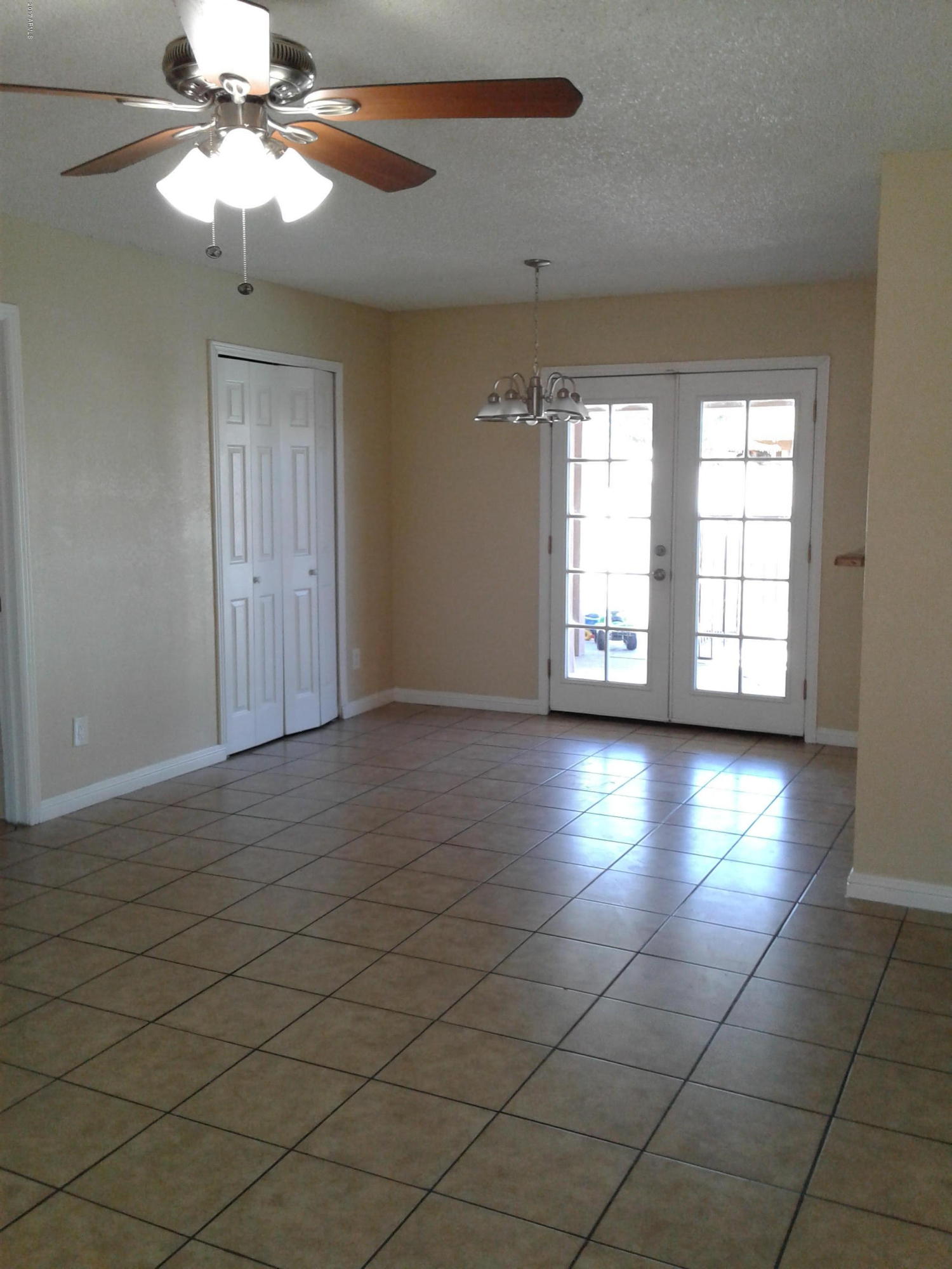 8416 West Roma Avenue Phoenix, AZ 85037 - Photo 7 of 33 an empty room with windows and chandelier fan