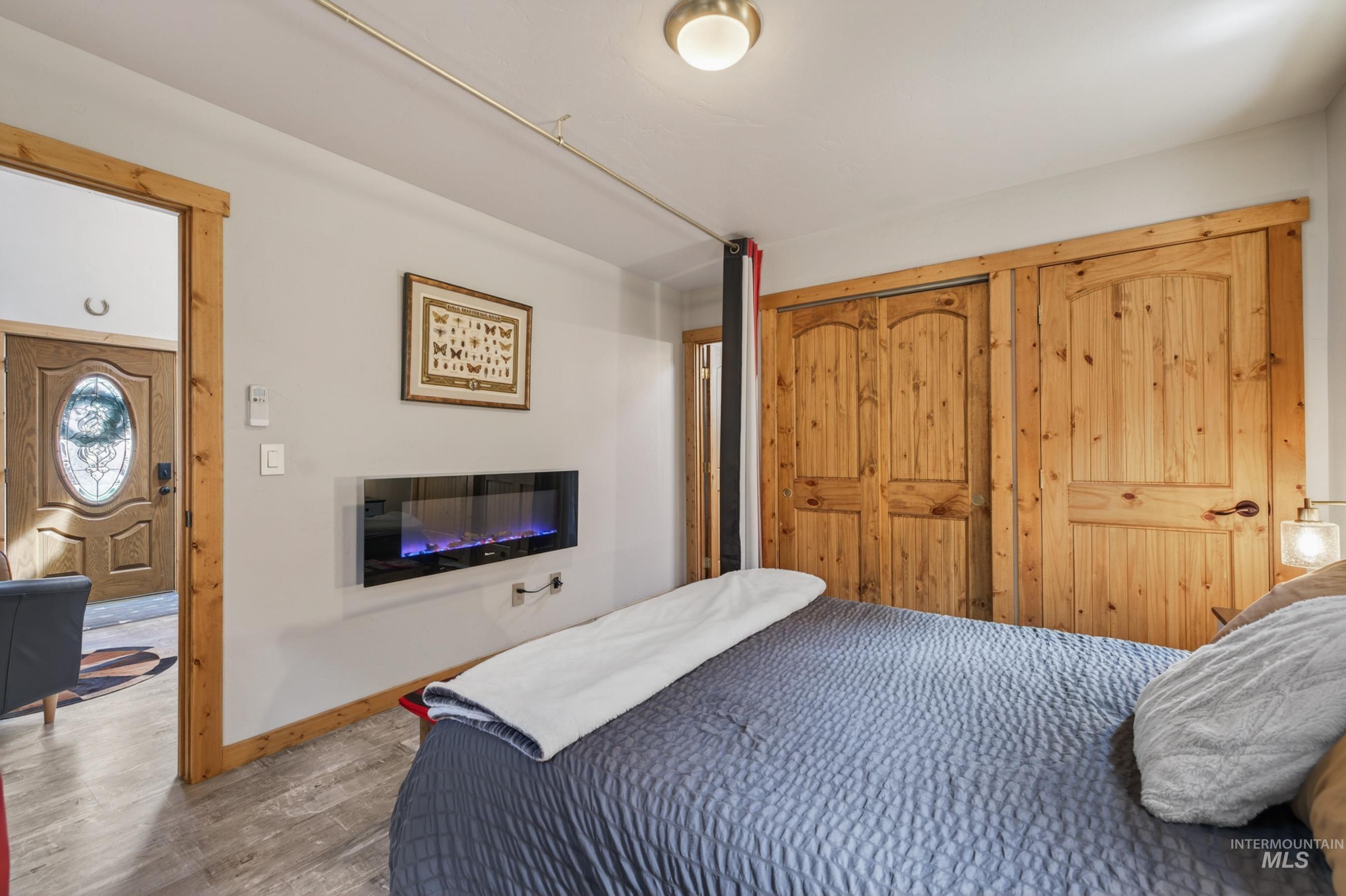 1432 Salmon Drive Riggins, ID 83549 - Photo 14 of 39 Bedroom featuring an electric fireplace and wood-finish flooring