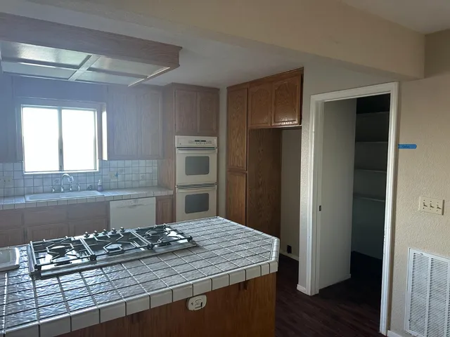 a kitchen with kitchen island granite countertop a refrigerator stove and sink