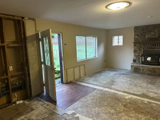 a view of an empty room with a fireplace and a window