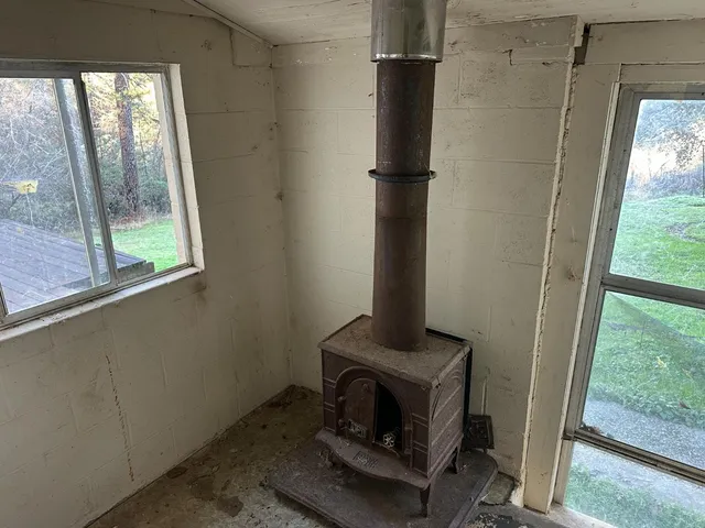 a living room with a floor to ceiling window and a fireplace