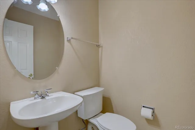 a bathroom with a toilet a sink and a mirror