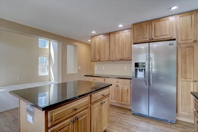 a kitchen with kitchen island granite countertop a sink cabinets and stainless steel appliances