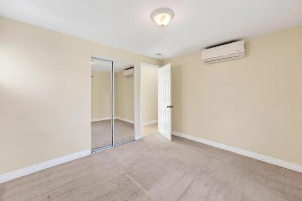 an empty room with closet and entryway