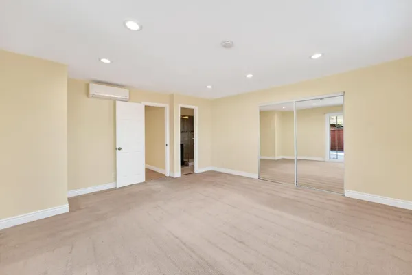 a view of an empty room with closet and entryway