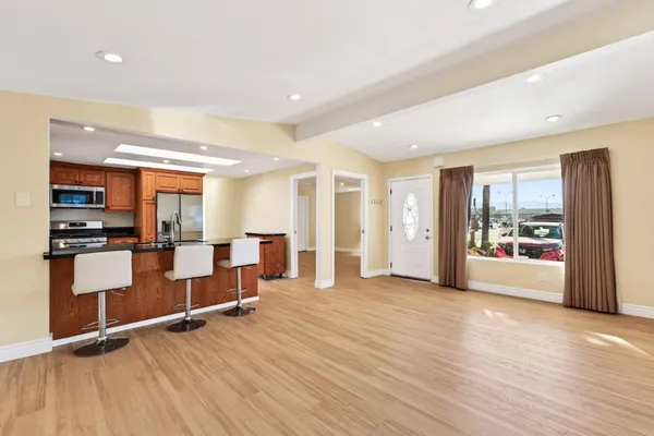 a view of a kitchen with refrigerator and wooden floor