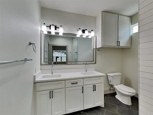 a bathroom with a toilet sink and mirror