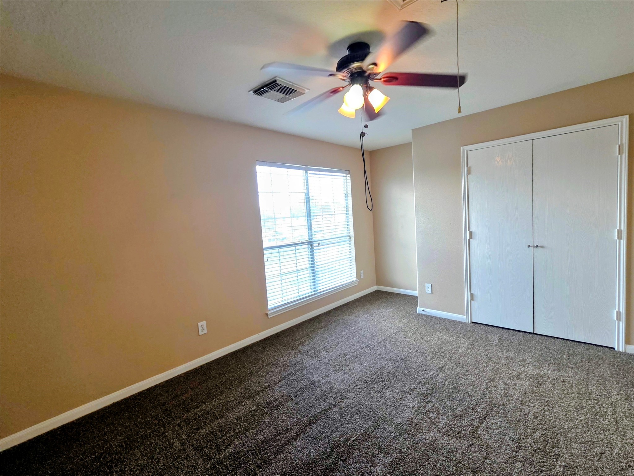 24235 Stargazer Point Spring, TX 77373 - Photo 12 of 21 an empty room with a chandelier fan and windows