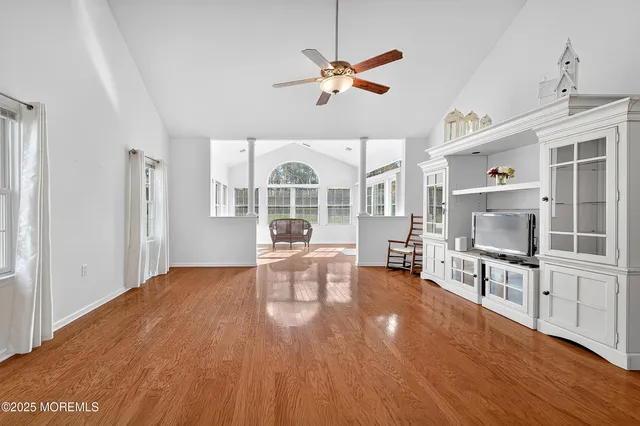 a view of a livingroom with furniture a ceiling fan and wooden floor