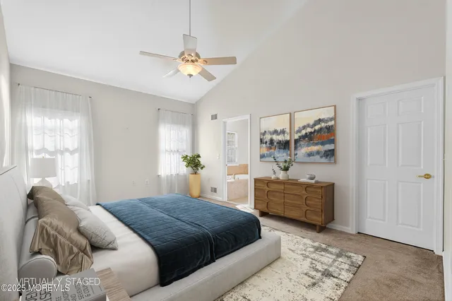 a spacious bedroom with a bed and ceiling fan