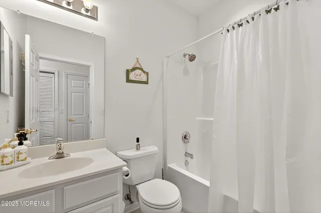 a bathroom with a sink a toilet and shower curtain