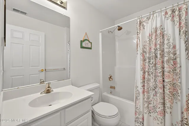 a bathroom with a sink a toilet and shower curtain
