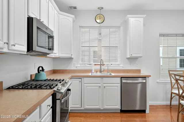 a kitchen with stainless steel appliances granite countertop a sink stove and cabinets