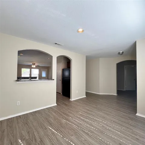 a view of empty room with wooden floor and entryway