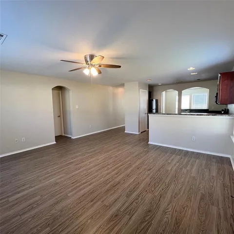 a view of a kitchen with wooden floor and a ceiling fan