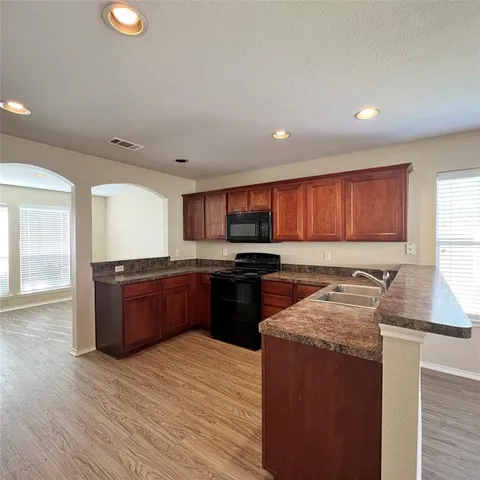 a kitchen with stainless steel appliances granite countertop a stove a sink and a refrigerator
