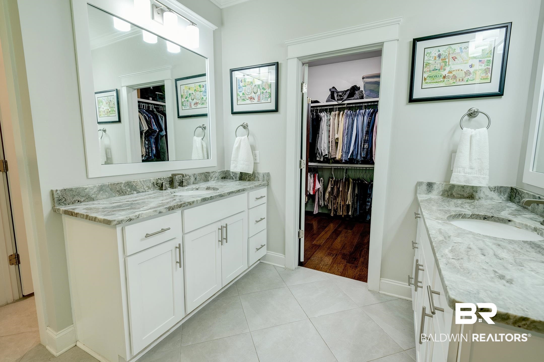 18754 Treasure Oaks Road Gulf Shores, AL 36542 - Photo 20 of 53 Dual white vanity cabinets with undermount sinks, stone countertops, and square mirrors featuring vanity lighting