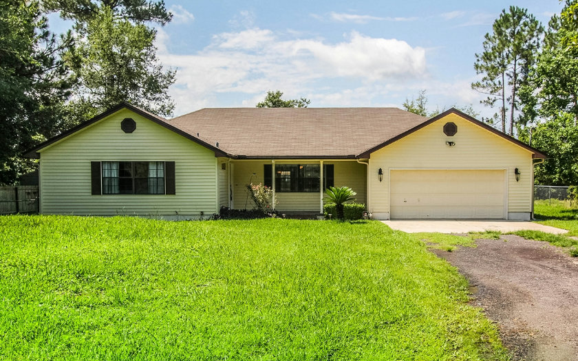 75043 Edwards Road Yulee, FL 32097 - Photo 1 of 21 a front view of a house with a yard and garage