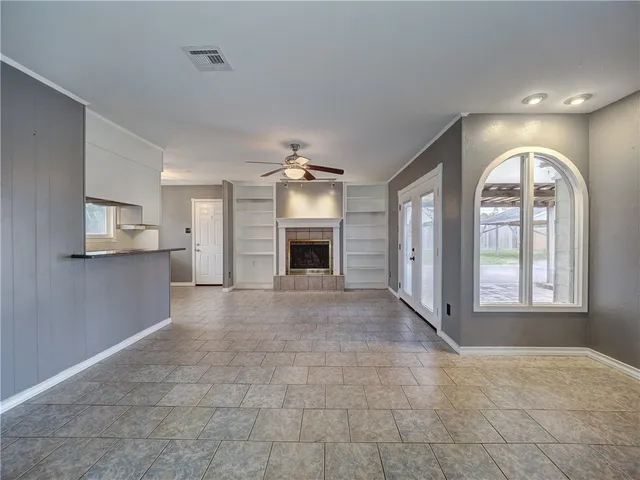 a view of an empty room with a fireplace and a window