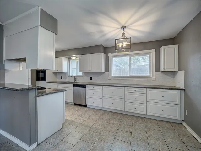 a kitchen with cabinets appliances and a window