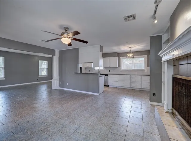a view of a kitchen with a stove cabinets a ceiling fan and wooden floor