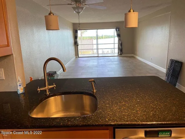 a kitchen with stainless steel appliances granite countertop a refrigerator a stove and a sink