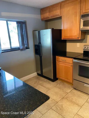 a kitchen with granite countertop a sink a stove and cabinets