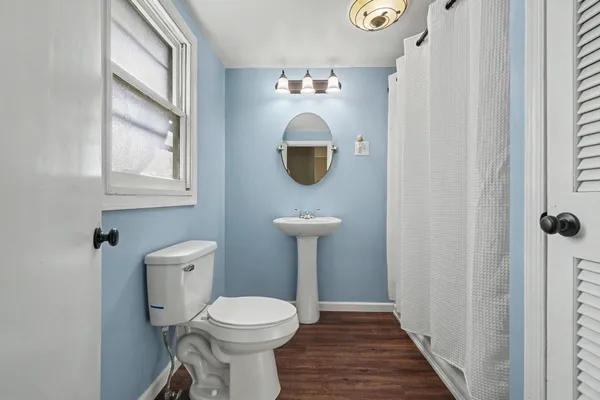 a bathroom with a toilet sink and mirror