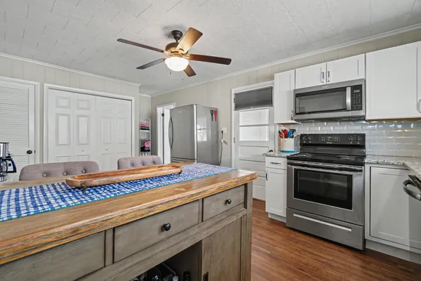 a kitchen with stainless steel appliances kitchen island granite countertop a sink and cabinets