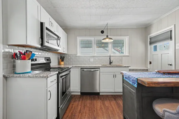 a kitchen with a sink cabinets and wooden floor