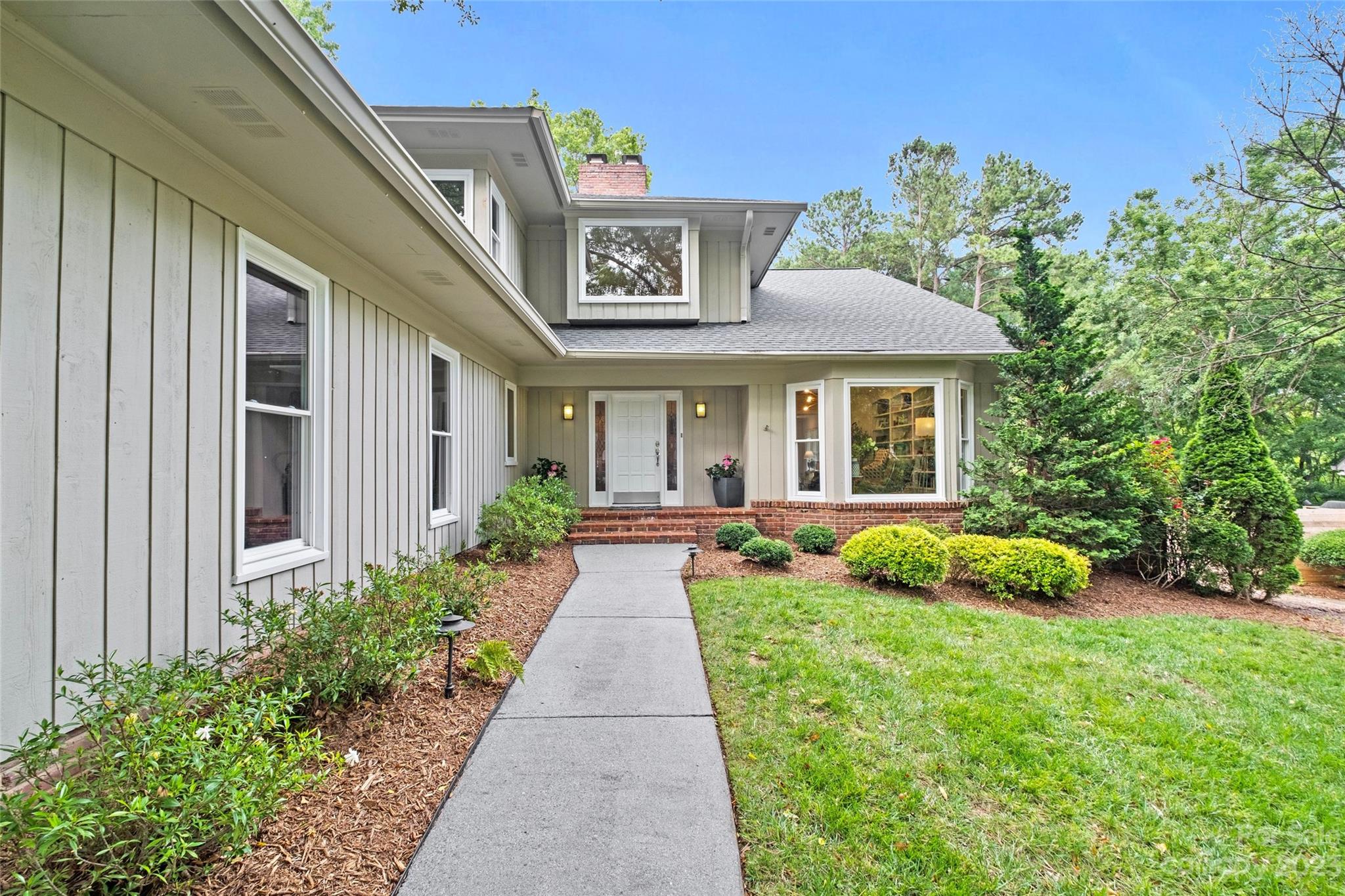 5013 Morrowick Road Charlotte, NC 28226 - Photo 4 of 48 a view of a house with brick walls plants and large windows