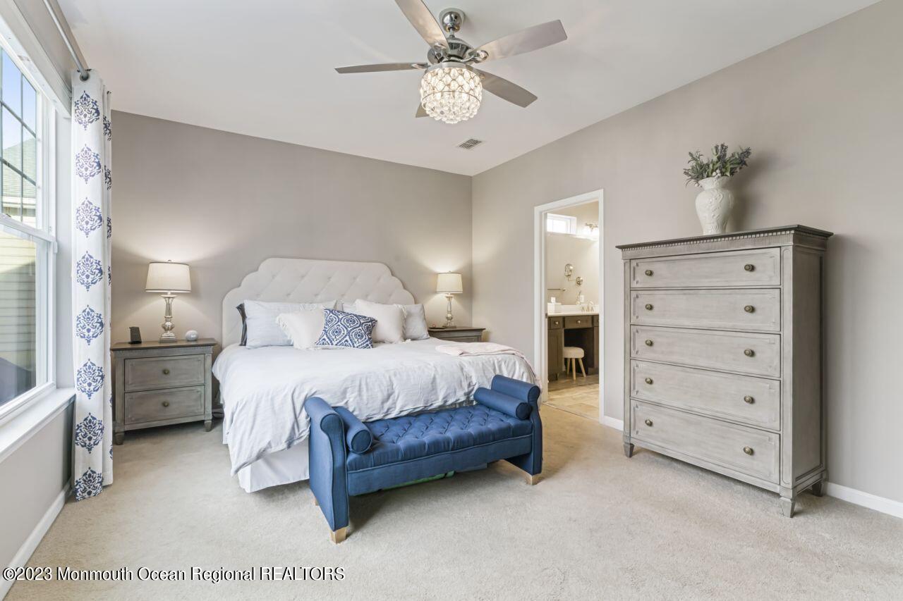 68 Harvest Ridge Road Howell, NJ 07731 - Photo 29 of 45 a spacious bedroom with a bed and a chandelier