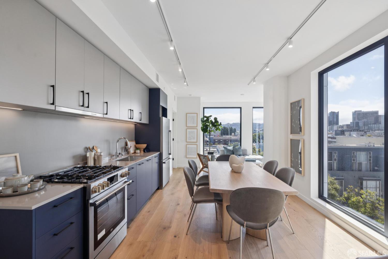 988 Harrison Street, Unit CN9 San Francisco, CA 94107 - Photo 1 of 16 a kitchen with granite countertop a stove a sink a refrigerator dining table and chairs