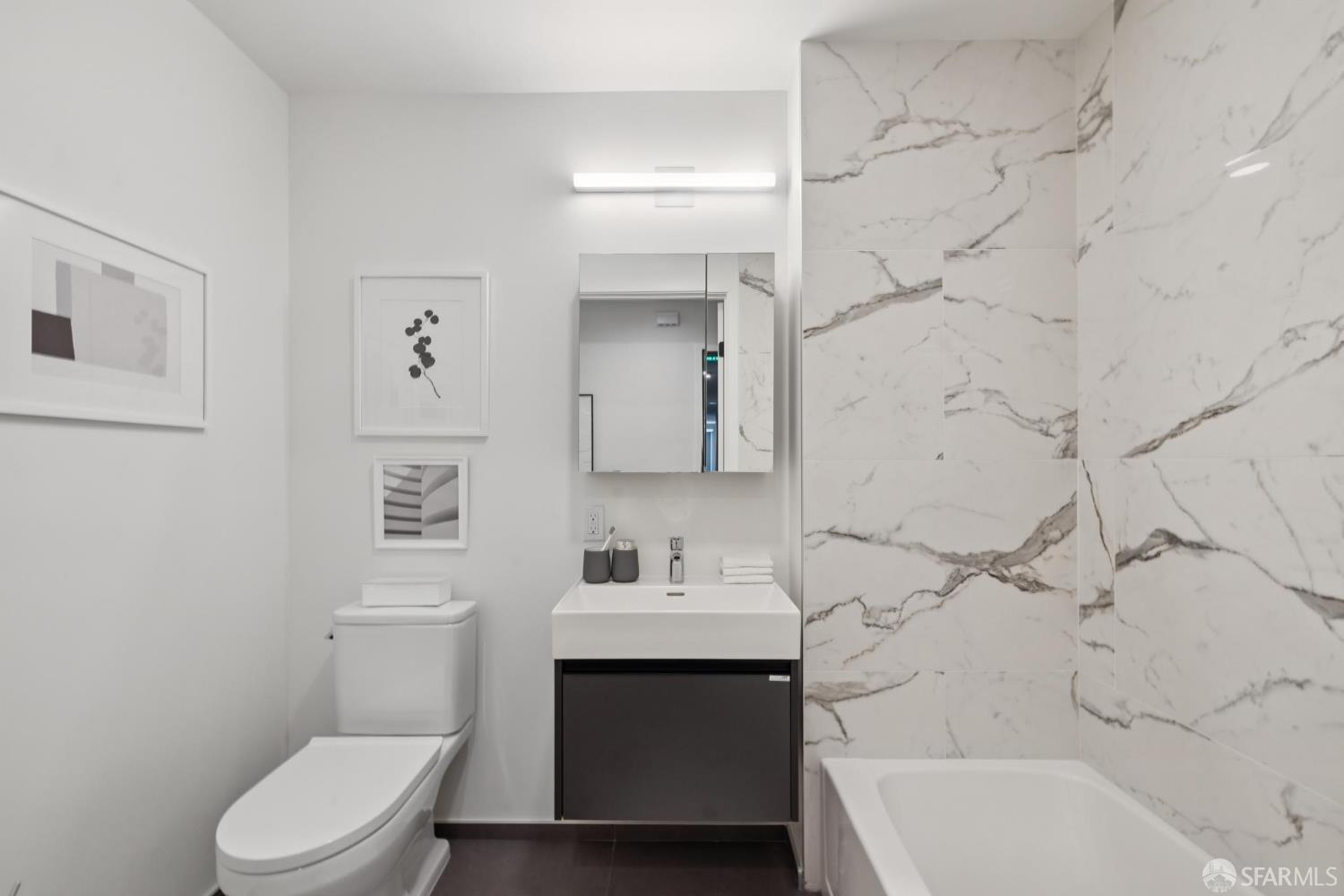 988 Harrison Street, Unit CN9 San Francisco, CA 94107 - Photo 11 of 16 a bathroom with a sink toilet vanity and bathtub