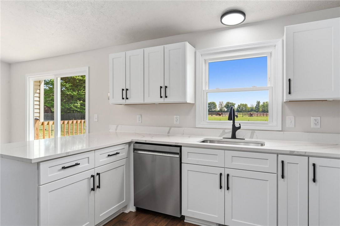 1353 Foust Road Xenia, OH 45385 - Photo 35 of 50 This kitchen features sleek countertops, ample cabinetry, and a sliding door leading to an outdoor area.