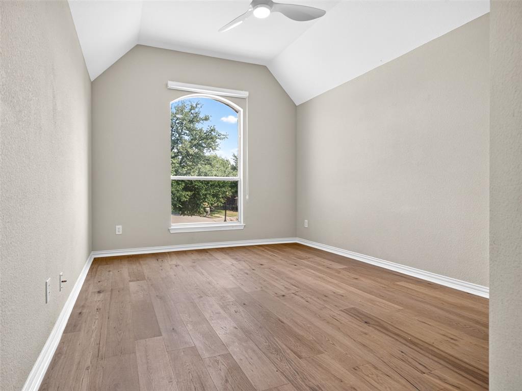 6809 Cedar Ridge Court Plano, TX 75093 - Photo 27 of 38 Vaulted ceiling with an integrated ceiling fan, wood-finish flooring, and an arched window