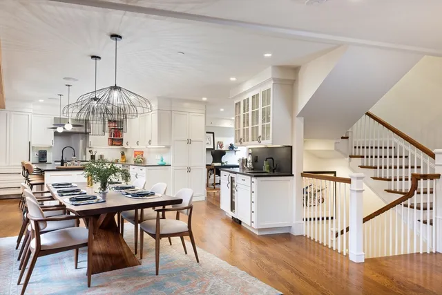 a kitchen with stainless steel appliances kitchen island granite countertop a table chairs and a wooden floor