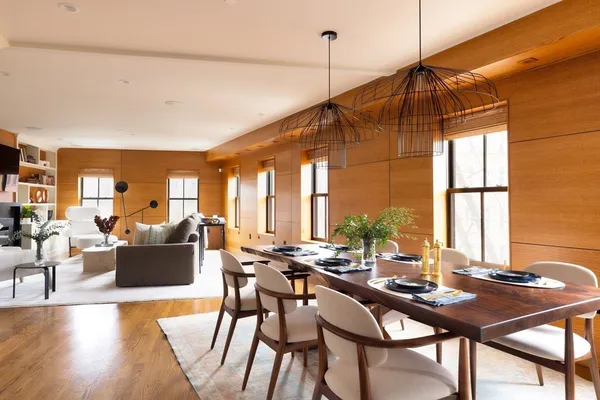 a view of a dining room and livingroom with furniture wooden floor a chandelier