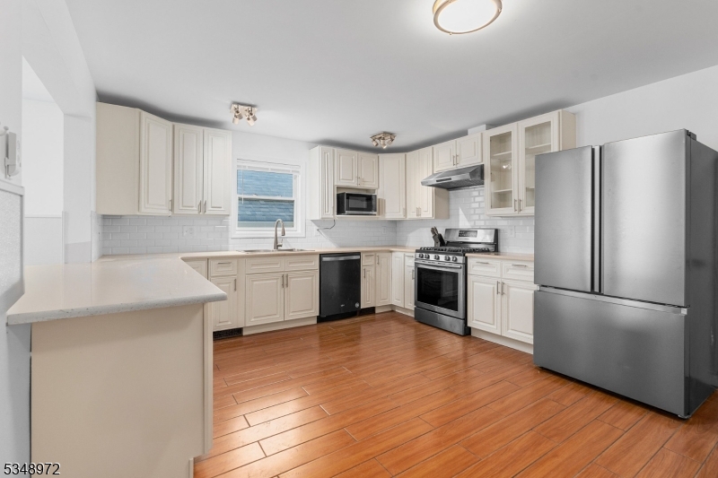 129 Franklin Avenue, Unit A Seaside Heights, NJ 08751 - Photo 3 of 14 a kitchen with a refrigerator a sink a stove top oven and white cabinets
