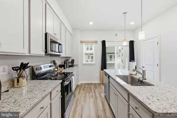 a kitchen with granite countertop a sink stove and refrigerator