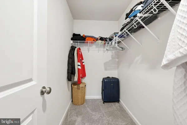 a view of a hallway with wooden cabinets