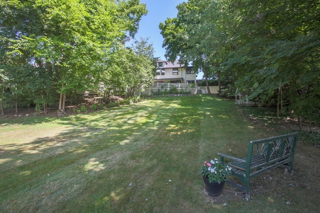 40 Windsor Road Newton, MA 02468 - Photo 26 of 29 a backyard of a house with table and chairs and potted plants