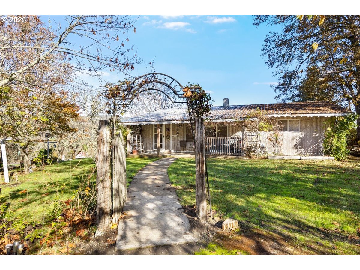 3620 Happy Valley Road Roseburg, OR 97471 - Photo 2 of 25 a view of a big yard with plants and a bench