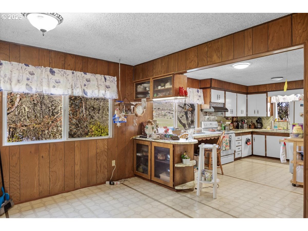 3620 Happy Valley Road Roseburg, OR 97471 - Photo 9 of 25 a kitchen with stainless steel appliances kitchen island granite countertop a table chairs and a wooden cabinets