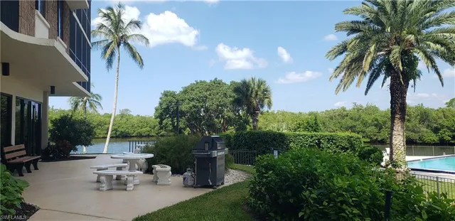 a view of a patio with table and chairs potted plants and palm tree