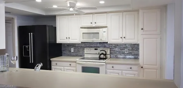 a kitchen with stainless steel appliances white cabinets and a refrigerator